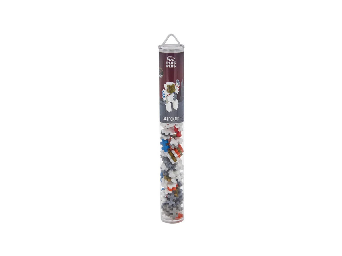 A tall, narrow clear plastic tube filled with small multicolored building-brick-like pieces, with a dark printed label near the top. The product is photographed upright on a plain white background.
